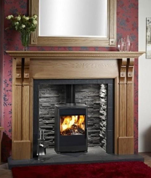 Modern style wood burning stove in dark brick lined fireplace
