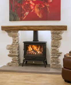 Rustic stone surrounds and timber mantel above a wood burning stove