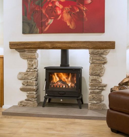 Rustic stone surrounds and timber mantel above a wood burning stove
