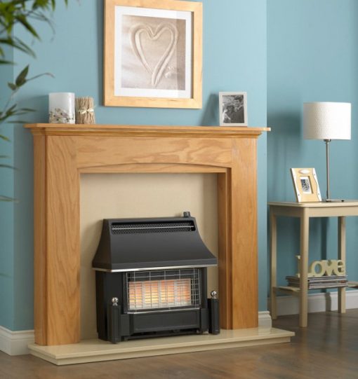 Older style black fire sits in wooden surround